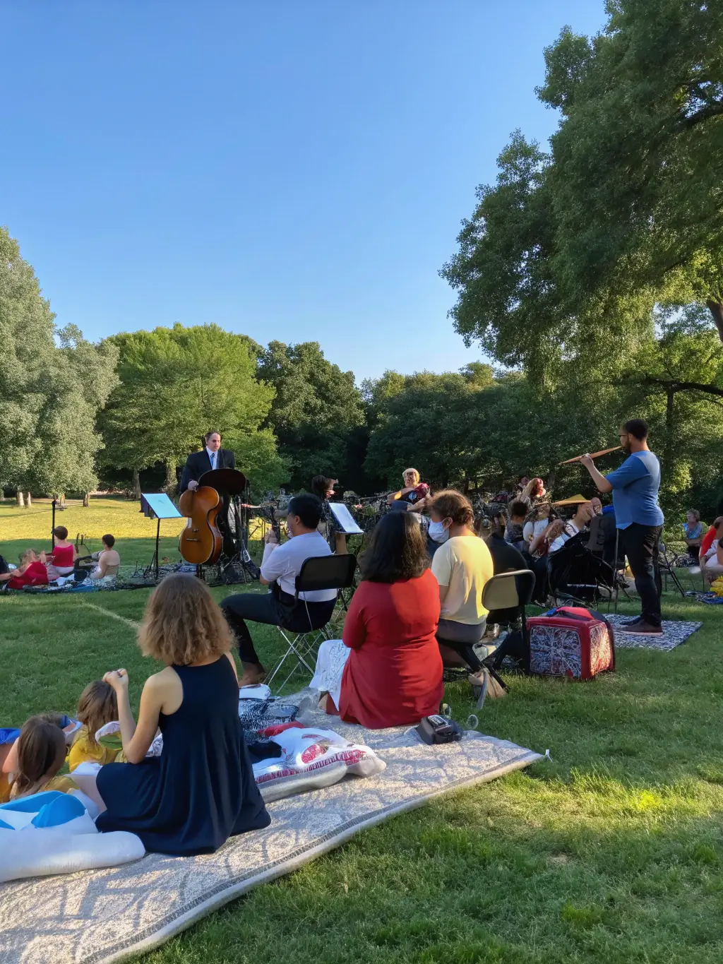 A captivating shot of a BLACK HATS performance in a public space, with people of all ages and backgrounds enjoying the music and atmosphere, emphasizing the accessibility and community engagement.
